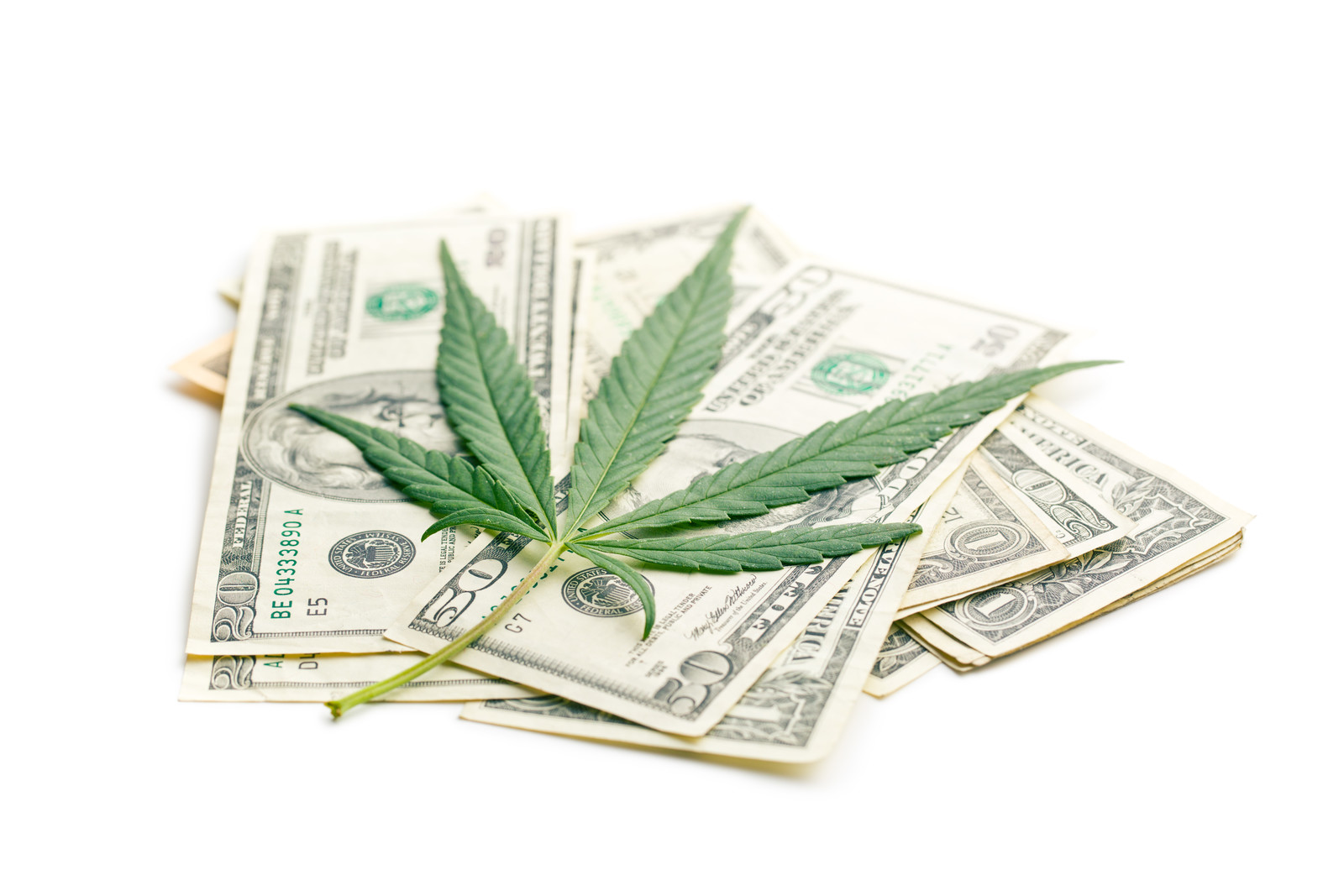 Methods for buying pot. Marijuana leaf on a pile of money.