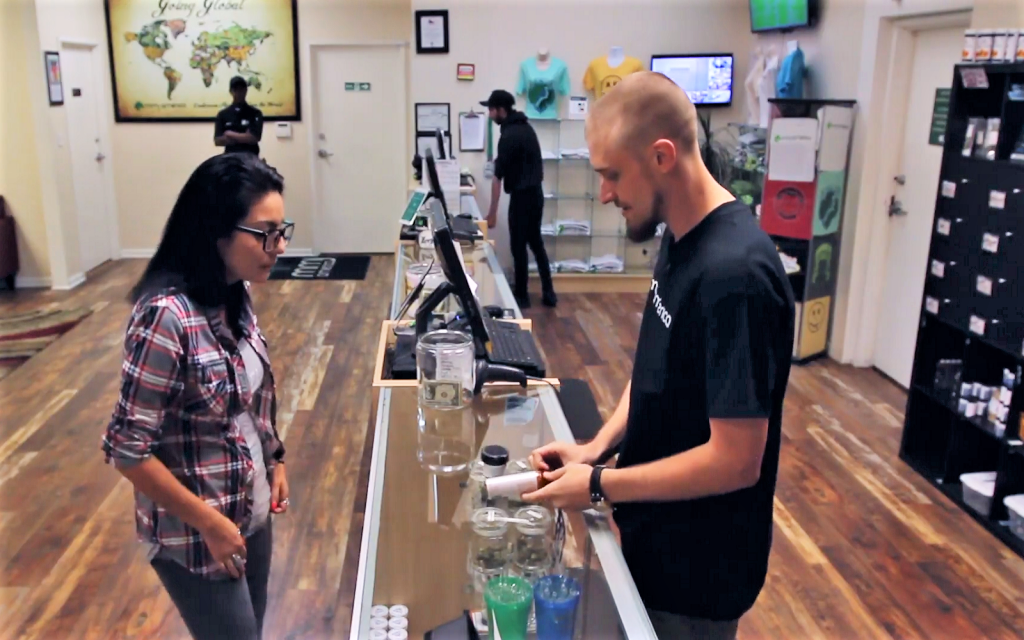 Best practices for marijuana retail hiring. Customer and worker in dispensary.