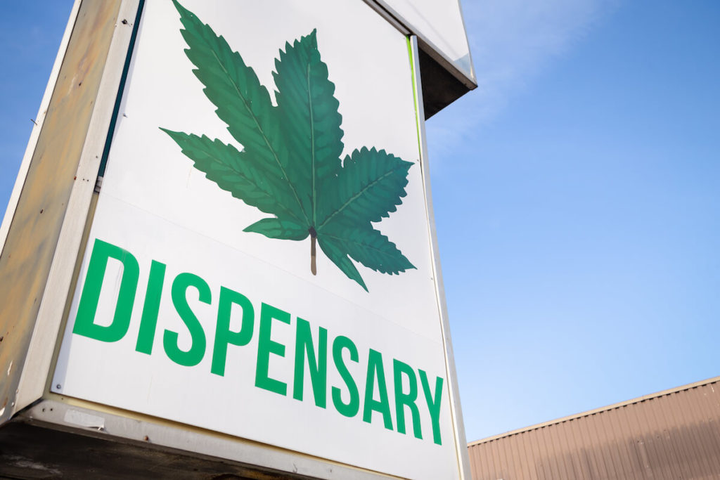 What You Need to Know When Selling Your Cannabis Dispensary. A store sign with a marijuana leaf and the word "dispensary."