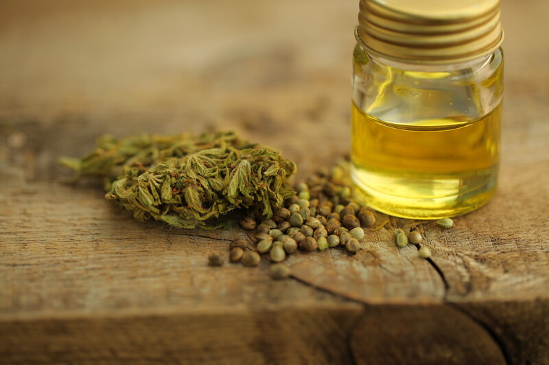 cannabis buds and seeds next to cbd oil, CBD and health benefits
