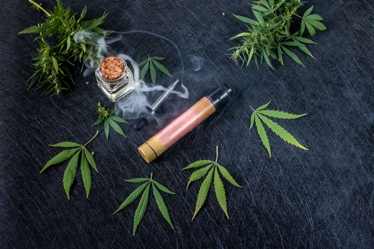Cannabis liquid. Vape CBD or THC, Vaping Marijuana Leaves Hemp. On a dark background, how to choose a weed vaporizer