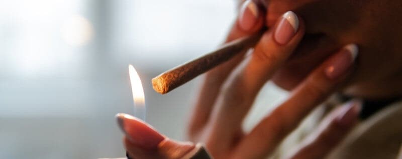 women lighting a cannabis joint, Beginners Guide on How to Smoke Cannabis Correctly