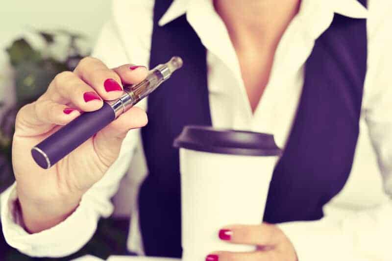 women holding coffee and a vape, consumption methods for cannabis