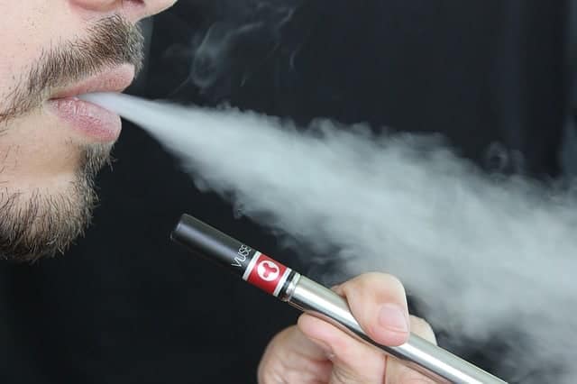 man blowing smoke from a vape, vaping THC
